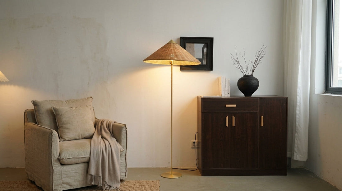 JINSHE Douli Rattan Floor Lamp casting a warm downward wash next to a dark oak cabinet and dry branches